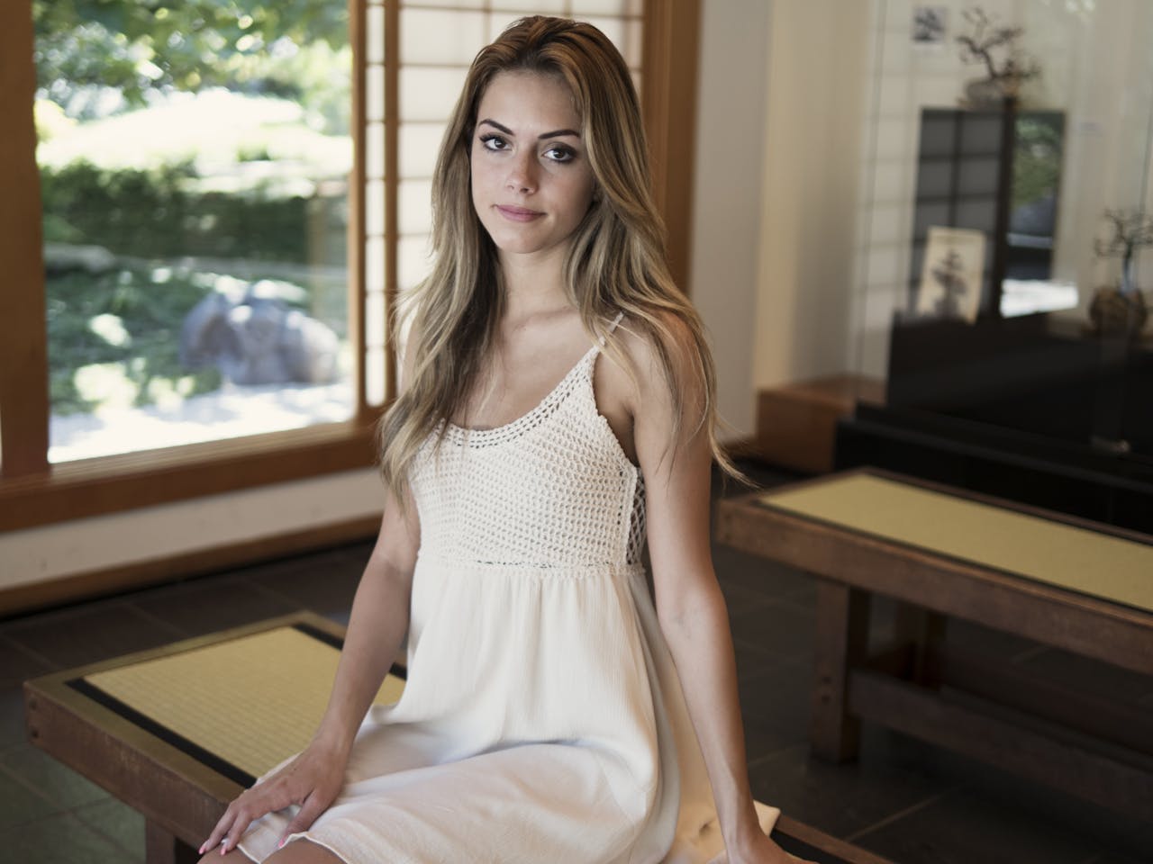 A serene portrait of a woman sitting indoors in natural light.